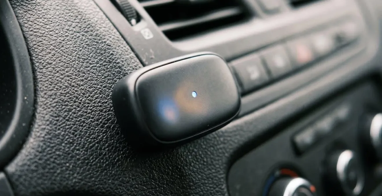 Gros plan sur un boîtier d'assurance connectée installé sur le tableau de bord d'une voiture.