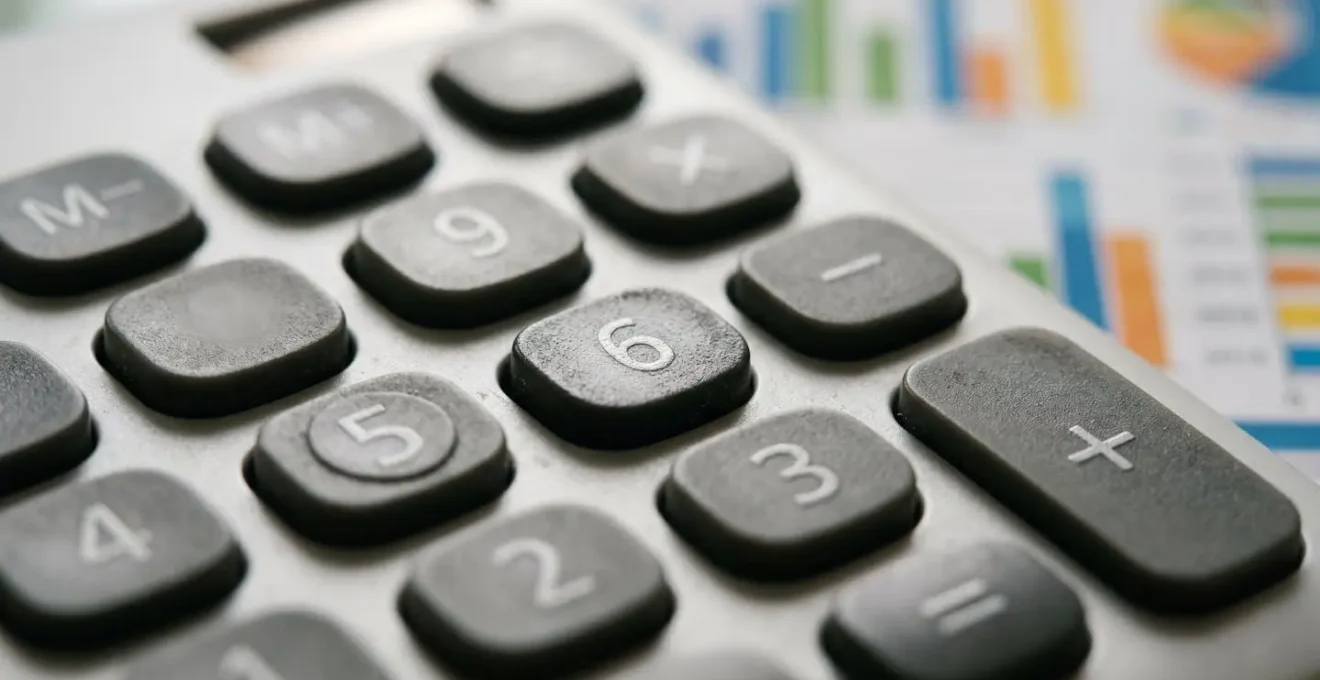Gros plan sur une calculatrice moderne et des graphiques financiers abstraits sur une table